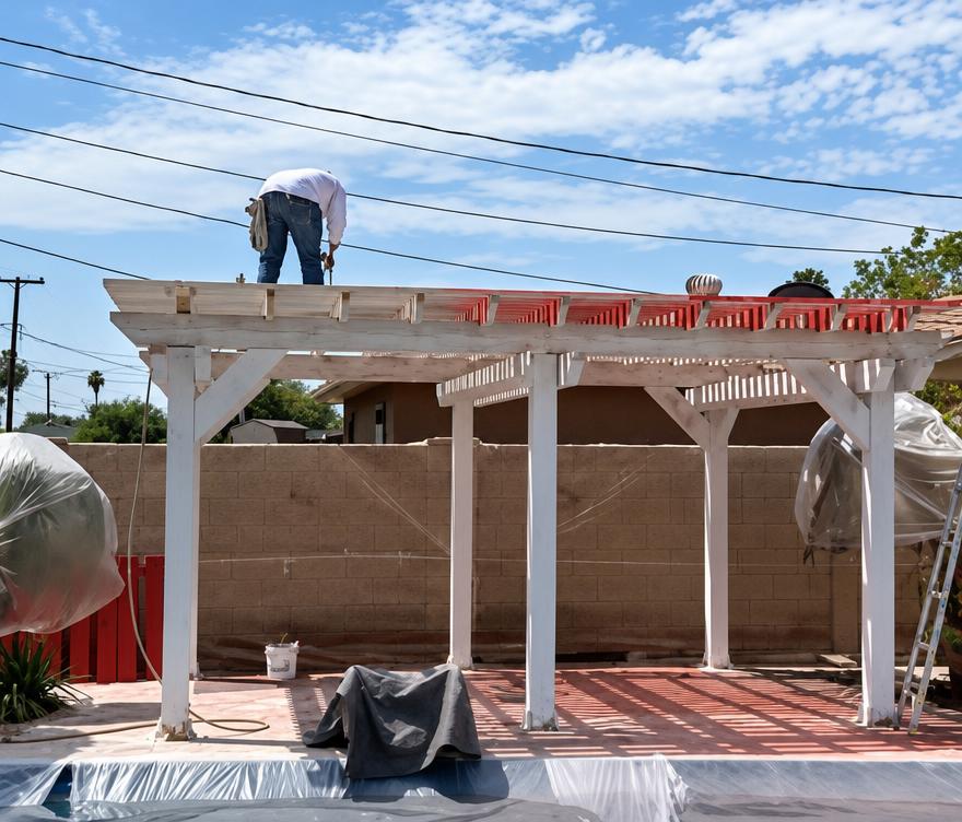 A & J Painting crew member working on a backyard pergola