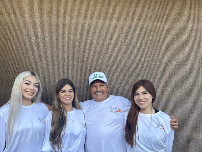 A & J Painting Services family team in branded shirts standing together